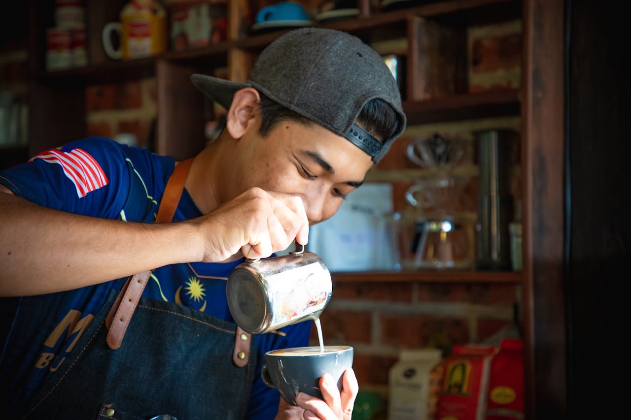 Skilled barista perfecting latte art in a cozy cafe setting, showcasing precision and craft.